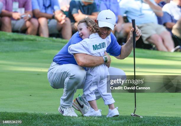Rory McIlroy of Northern Ireland embraces his daughter Poppy on the ninth green during the par 3 competition prior to the 2023 Masters Tournament at...