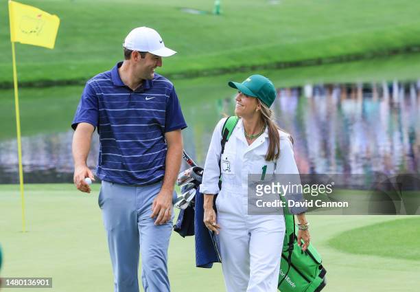 Scottie Scheffler of The United States walks with his wife Meredith Scheffler carrying his golf bag during the par 3 competition prior to the 2023...
