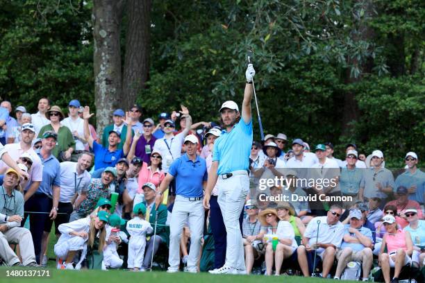 Tommy Fleetwood of England reacts to his tee shot going close on the sixth hole as Rory McIlory looks on during the par 3 competition prior to the...