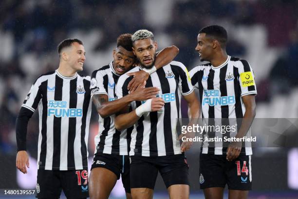Joelinton of Newcastle United is congratulated by Joe Willock after scoring the team's fifth goal during the Premier League match between West Ham...