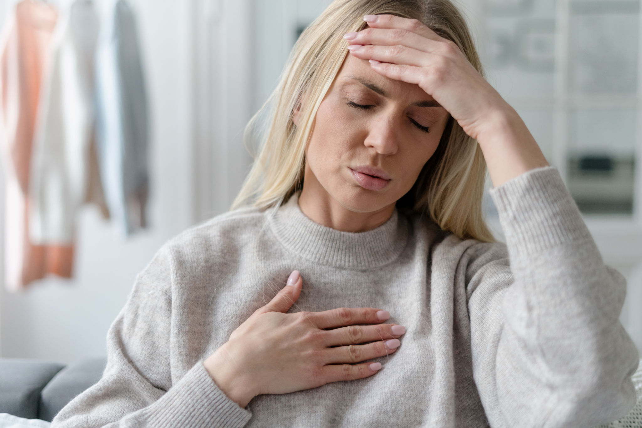 unhealthy woman in fever touching forehead and chest unhealthy woman in fever touching forehead and chest