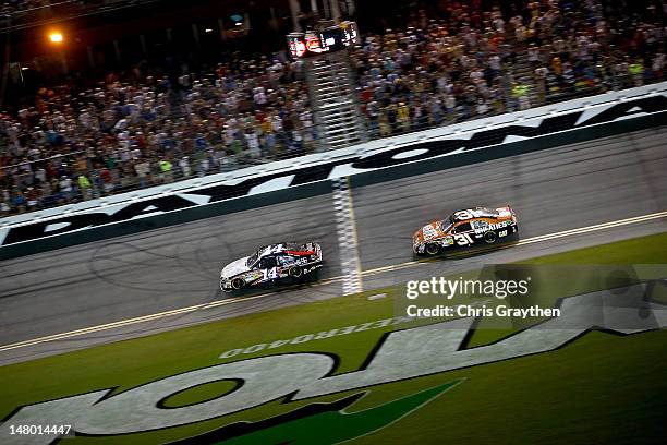 Tony Stewart, driver of the Mobil 1/Office Depot Chevrolet, crosses the finish line ahead of Jeff Burton, driver of the Wheaties Chevrolet, to win...