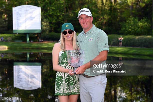 Tom Hoge of the United States and his wife, Kelly, pose with the Par 3 contest trophy prior to the 2023 Masters Tournament at Augusta National Golf...