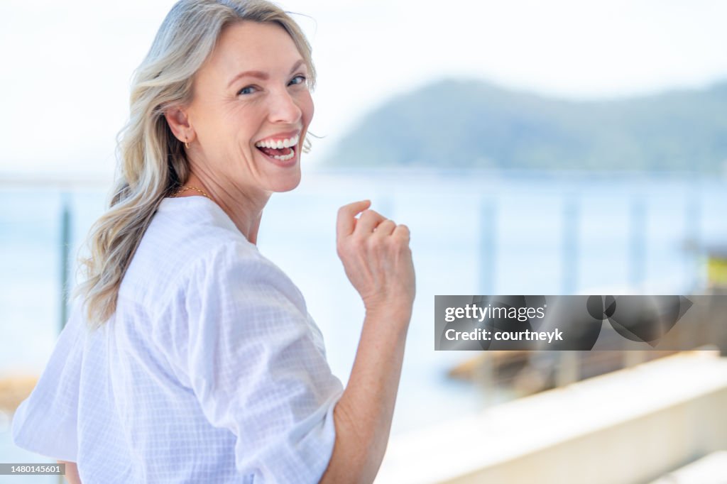 Beautiful mature woman portrait at waterfront house.