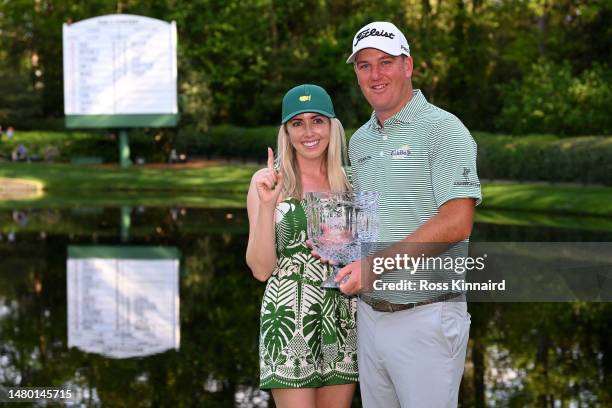 Tom Hoge of the United States and his wife, Kelly, pose with the Par 3 contest trophy prior to the 2023 Masters Tournament at Augusta National Golf...