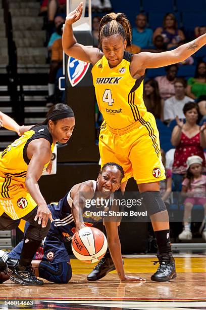 Allison Hightower of the Connecticut Sun loses control of the ball under pressure from Ivory Latta and Amber Holt of the Tulsa Shock during the WNBA...