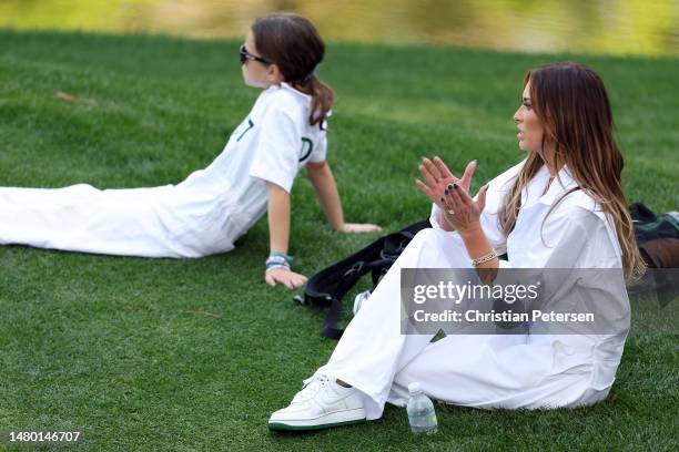 Dustin Johnson of the United States wife, Paulina Gretzky, looks on during the Par 3 contest prior to the 2023 Masters Tournament at Augusta National...