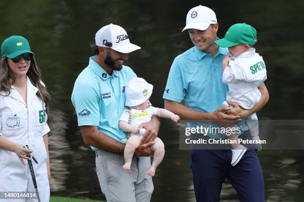Max Homa of the United States holds his son, Cam Homa, and Jordan Spieth of the United States holds his son, Sammy Spieth on the ninth green during...