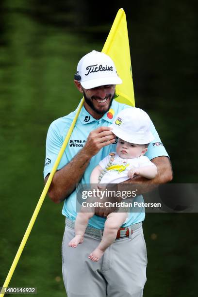 Max Homa of the United States holds his son Cam Homa on the ninth green during the Par 3 contest prior to the 2023 Masters Tournament at Augusta...