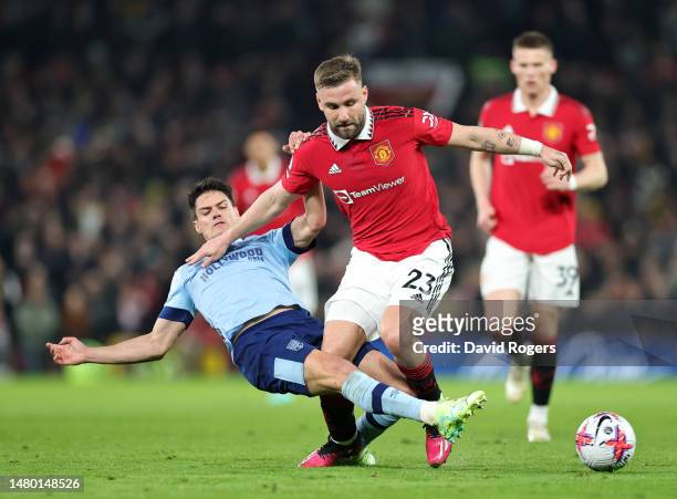 Luke Shaw of Manchester United is tackled by Christian Norgaard of Brentford during the Premier League match between Manchester United and Brentford...
