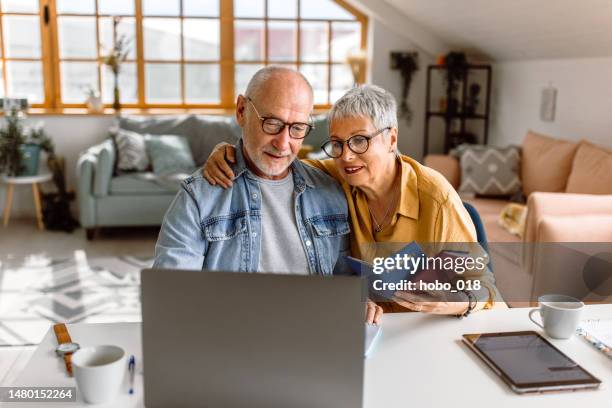 senior couple planning vacation trip and searching information on internet - vacation planning stock pictures, royalty-free photos & images