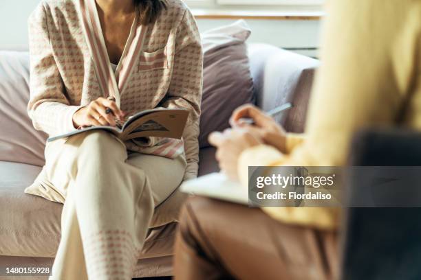 two women in armchairs are sitting and talking - psicoterapeuta foto e immagini stock