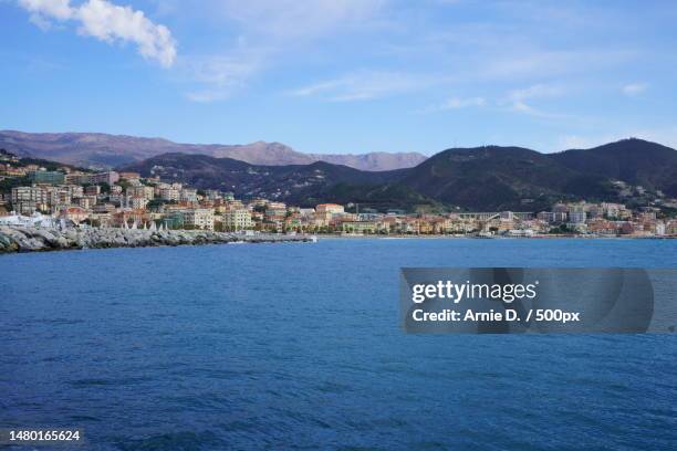 scenic view of sea by townscape against sky,varazze,italy - savona stock-fotos und bilder