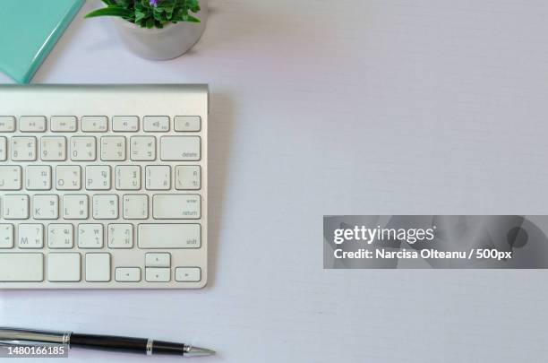 directly above shot of computer keyboard with book and pen on table,romania - open romania imagens e fotografias de stock