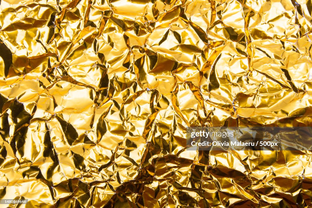 Gold crumpled foil paper texture background,Romania