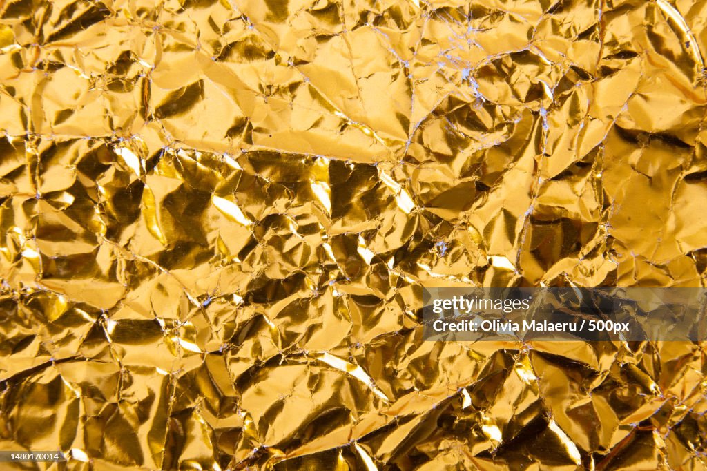 Gold crumpled foil paper texture background,Romania