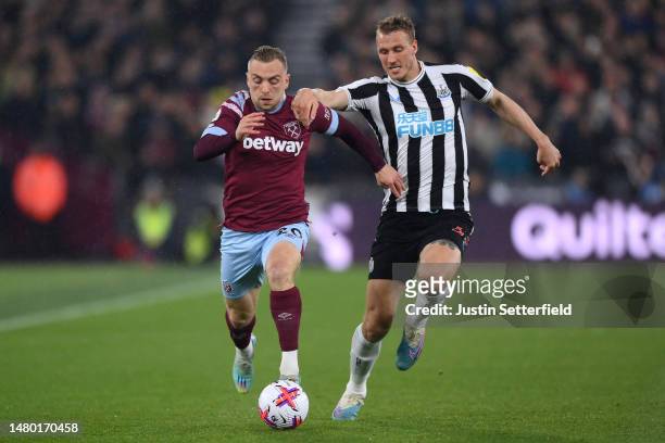 Jarrod Bowen of West Ham United and Dan Burn of Newcastle United compete for the ball during the Premier League match between West Ham United and...