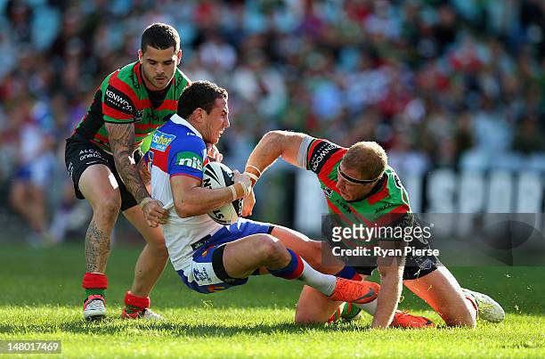 Darius Boyd of the Knights is tacked by Michael Crocker of the Rabbitohs during the round 18 NRL match between the South Sydney Rabbitohs and the...