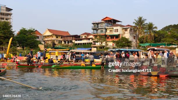 boote und touristen am yachthafen - vang vieng stock-fotos und bilder