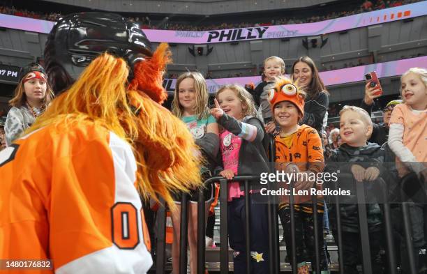 Young fans of the Philadelphia Flyers get the attention of Gritty the mascot of the Flyers during an NHL game against the Detroit Red Wings at the...