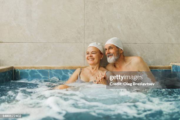 senior couple in love relaxing in hot tub. wellness in health resort - balneario fotografías e imágenes de stock
