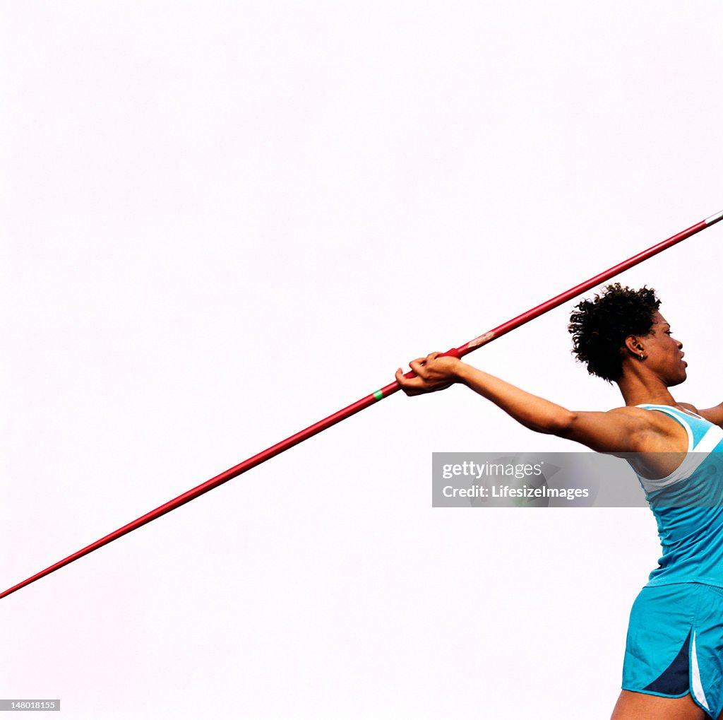 Woman throwing javelin, side view
