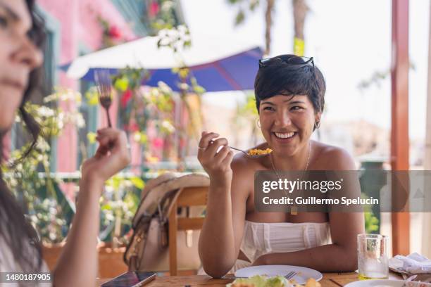 woman smiling while eating with friends in a restaurant - lima perú fotografías e imágenes de stock