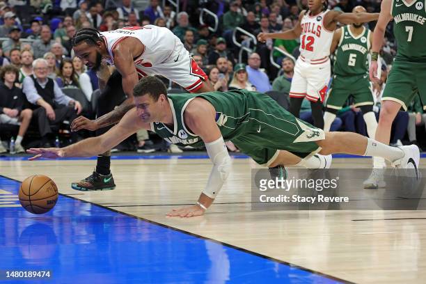 Brook Lopez of the Milwaukee Bucks and Derrick Jones Jr. #5 of the Chicago Bulls dive for a loose ball during the second half of a game at Fiserv...