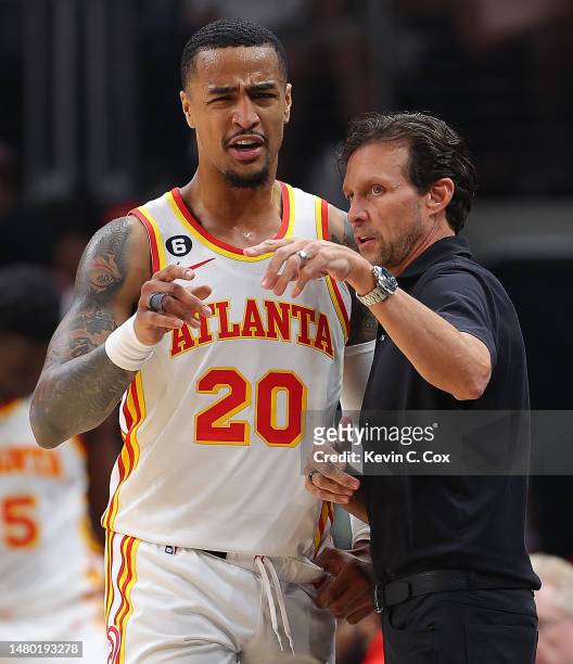 Head coach Quin Snyder of the Atlanta Hawks converses with John Collins against the Washington Wizards during the first quarter at State Farm Arena...