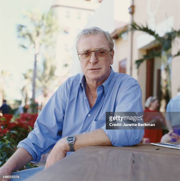Portrait of British actor Michael Caine as he poses at an outdoor restaurant, Miami, Florida, 2001.