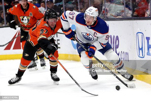 Connor McDavid of the Edmonton Oilers controls the puck past the defense of Mason McTavish of the Anaheim Ducks during the third period of a game at...