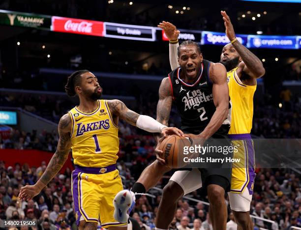 Kawhi Leonard of the LA Clippers reacts as he attempts a shot in front of D'Angelo Russell and LeBron James of the Los Angeles Lakers during a...