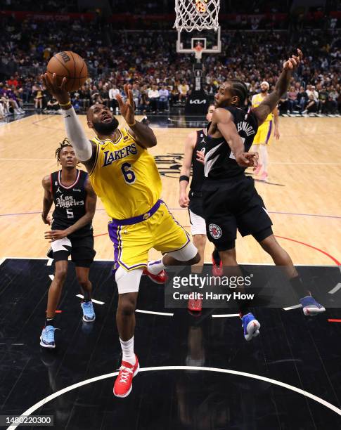 LeBron James of the Los Angeles Lakers scores on a layup past Kawhi Leonard and Bones Hyland of the LA Clippers during a 125-118 Clippers win at...
