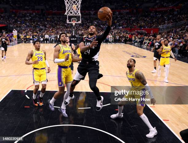 Norman Powell of the LA Clippers scores on a layup in front of D'Angelo Russell, Troy Brown Jr. #7 and Rui Hachimura of the Los Angeles Lakers during...