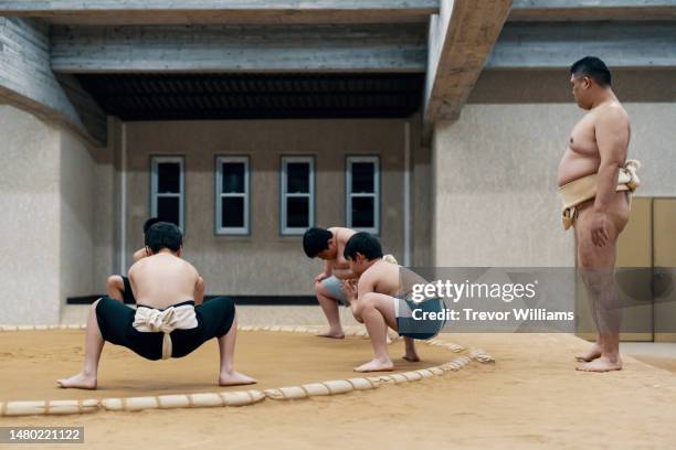 sumo coach supervising elementary school-aged students during a practice - westler stock pictures, royalty-free photos & images