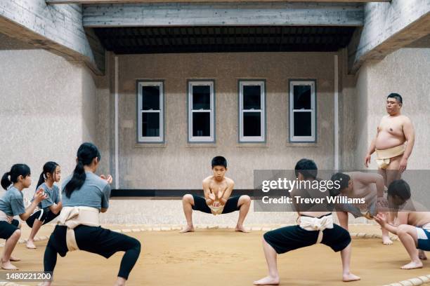 sumo coach supervising elementary school-aged students during a practice - female wrestling stock pictures, royalty-free photos & images