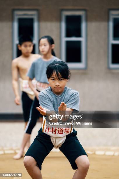 young elementary-aged girl concentrating at a sumo practice - female wrestling stock pictures, royalty-free photos & images