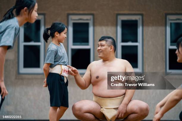 sumo coach supervising two elementary school-aged girls during a practice - female wrestling stock pictures, royalty-free photos & images