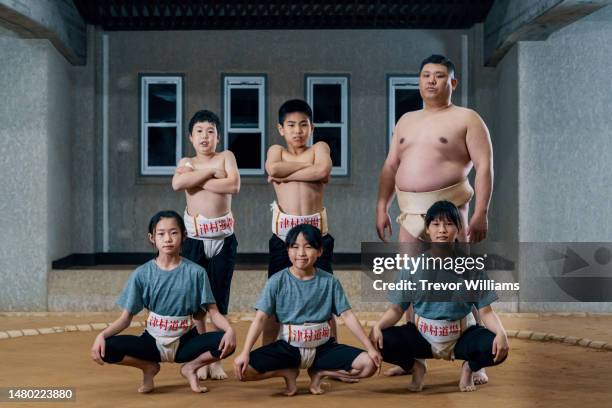 portrait of a sumo coach and his young elementary-aged students on a dohyo - sumo ストックフォトと画像