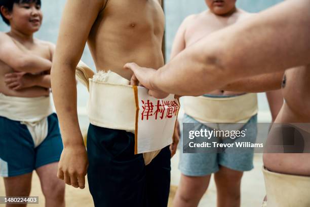 coach preparing elementary-aged students before sumo practice - female wrestling stock pictures, royalty-free photos & images