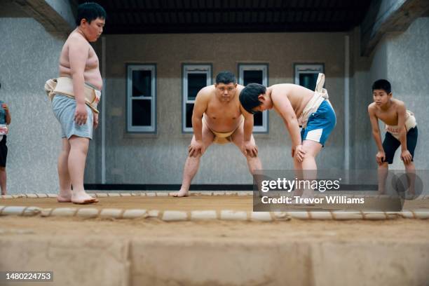 sumo coach supervising elementary school-aged students during a practice - female wrestling stock pictures, royalty-free photos & images