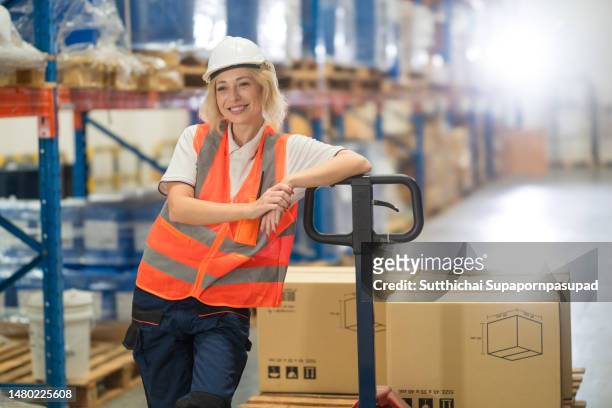 portrait of caucasian white female worker standing in the logistic warehouse with confident. - ständer stock-fotos und bilder