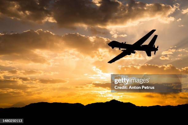 military unmanned aerial vehicle at sunset. combat drone in military conflicts - military attack stockfoto's en -beelden