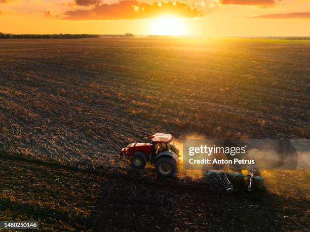 aerial view of a tractor plowing a field at sunset. preparing the field for sowing - ploughed field stock pictures, royalty-free photos & images