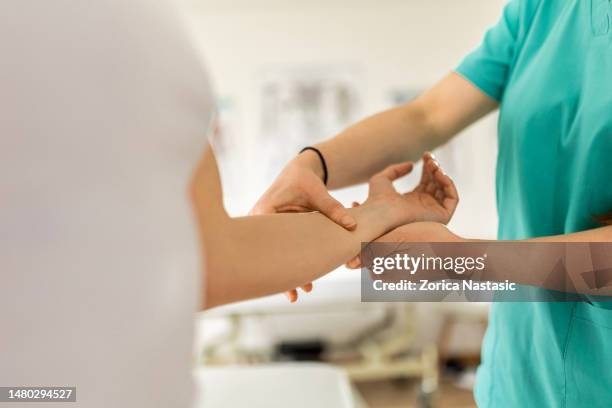 mujer joven en programa de fisioterapia para muñeca - pressure point fotografías e imágenes de stock