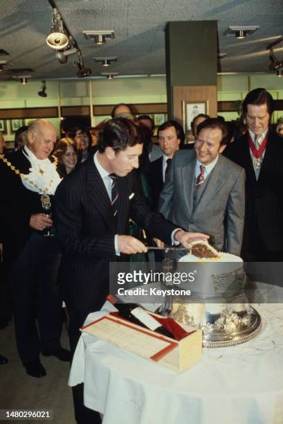 Charles, Prince of Wales pictured cutting a cake to celebrate his 30th birthday in an shop on Regent Street in London, England, 14th November 1978....