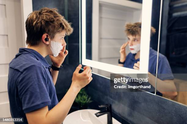 teenage boy is preparing to go out in a modern dark bathroom - teenage boy shave imagens e fotografias de stock