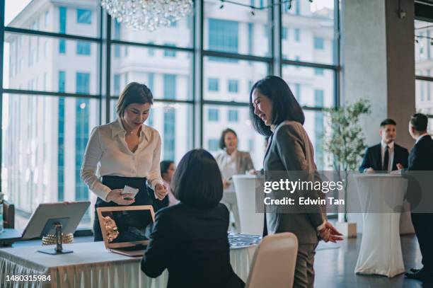 asian businesswoman registering at reception desk attending business conference seminar - party board meets stock pictures, royalty-free photos & images