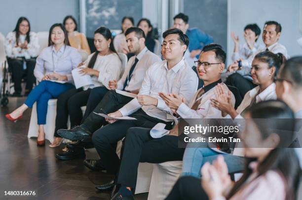asian seminar participants applauding listening to presenter on stage - corporate awards ceremony stock pictures, royalty-free photos & images