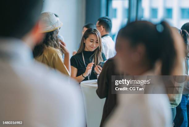 asian chinese female conference participant text messaging using smart phone during tea break - business conference stock pictures, royalty-free photos & images